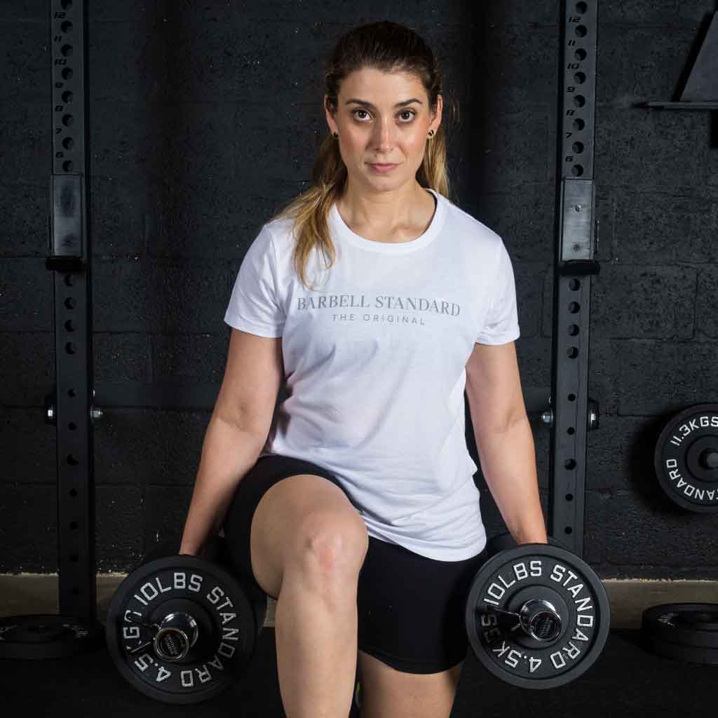 Barbell Standard 10 lb 4.5 kg iron weight plates used in dumbbell lunge exercise at gym