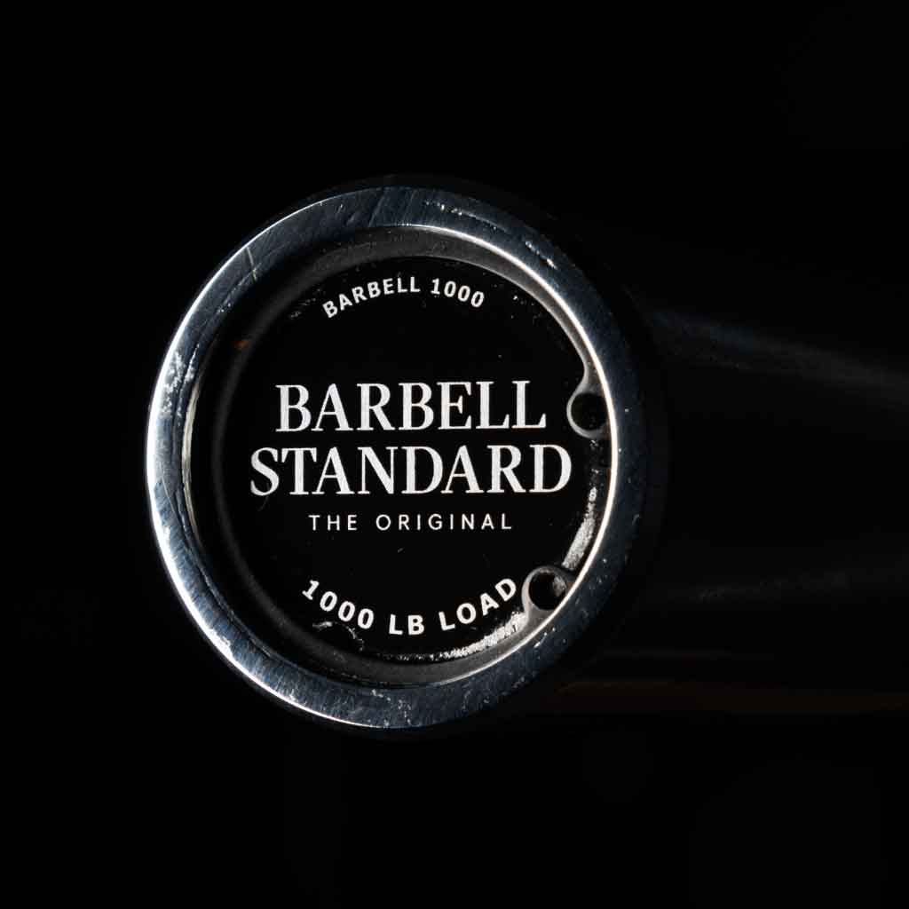 Barbell Standard 1000 lb load rating end cap close-up on Olympic barbell for weightlifting and strength training