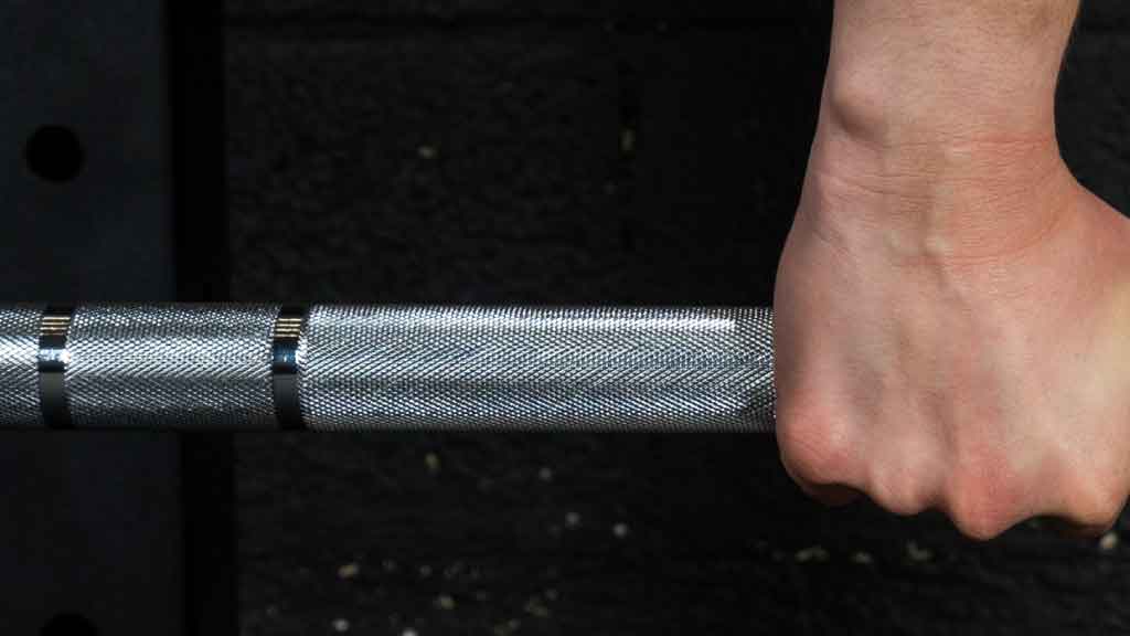 Barbell Standard 1000 training barbell with knurled grip and hand placement marks during workout