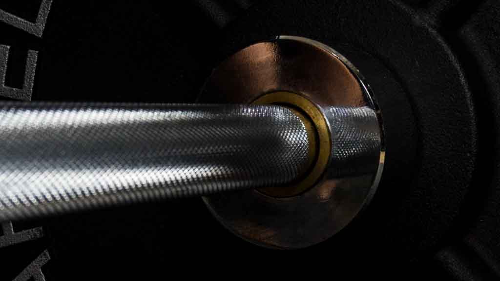 Barbell Standard 2000 power bar close up of bronze bushings and precision knurling for smooth spin and control