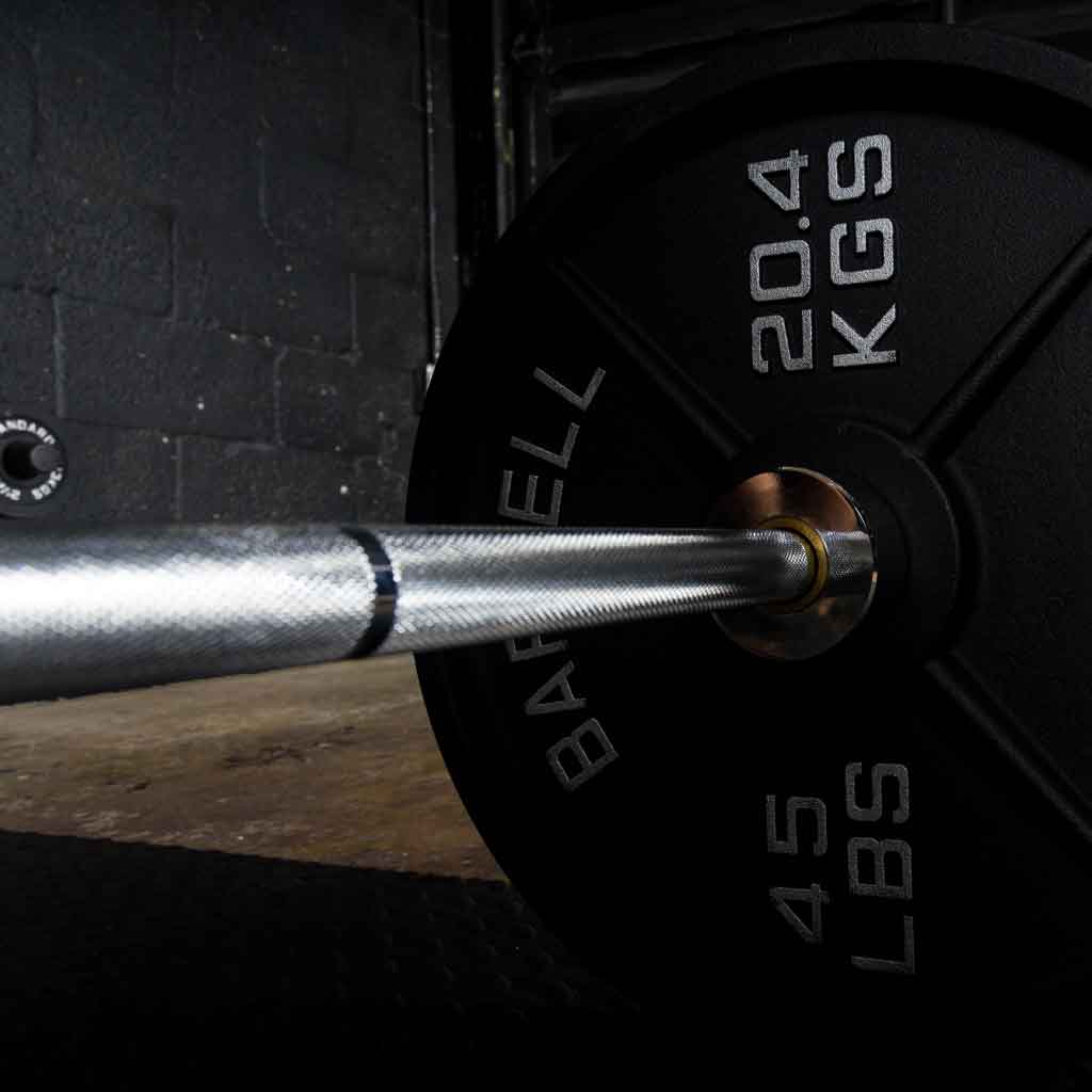 Close up of Barbell Standard Olympic barbell loaded with 20.4 kg 45 lb weight plate on gym floor
