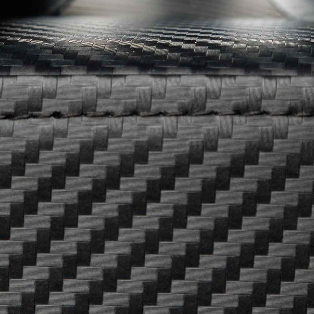 Close-up of Barbell Standard flat weight bench with durable textured carbon fiber style upholstery