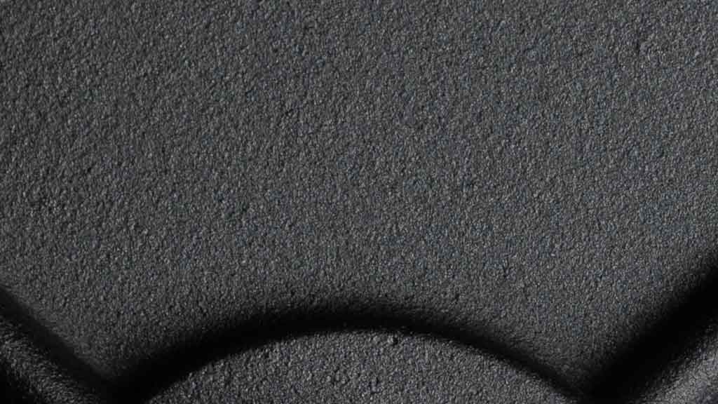 Close-up of black powder coat textured finish on cast iron weight plate