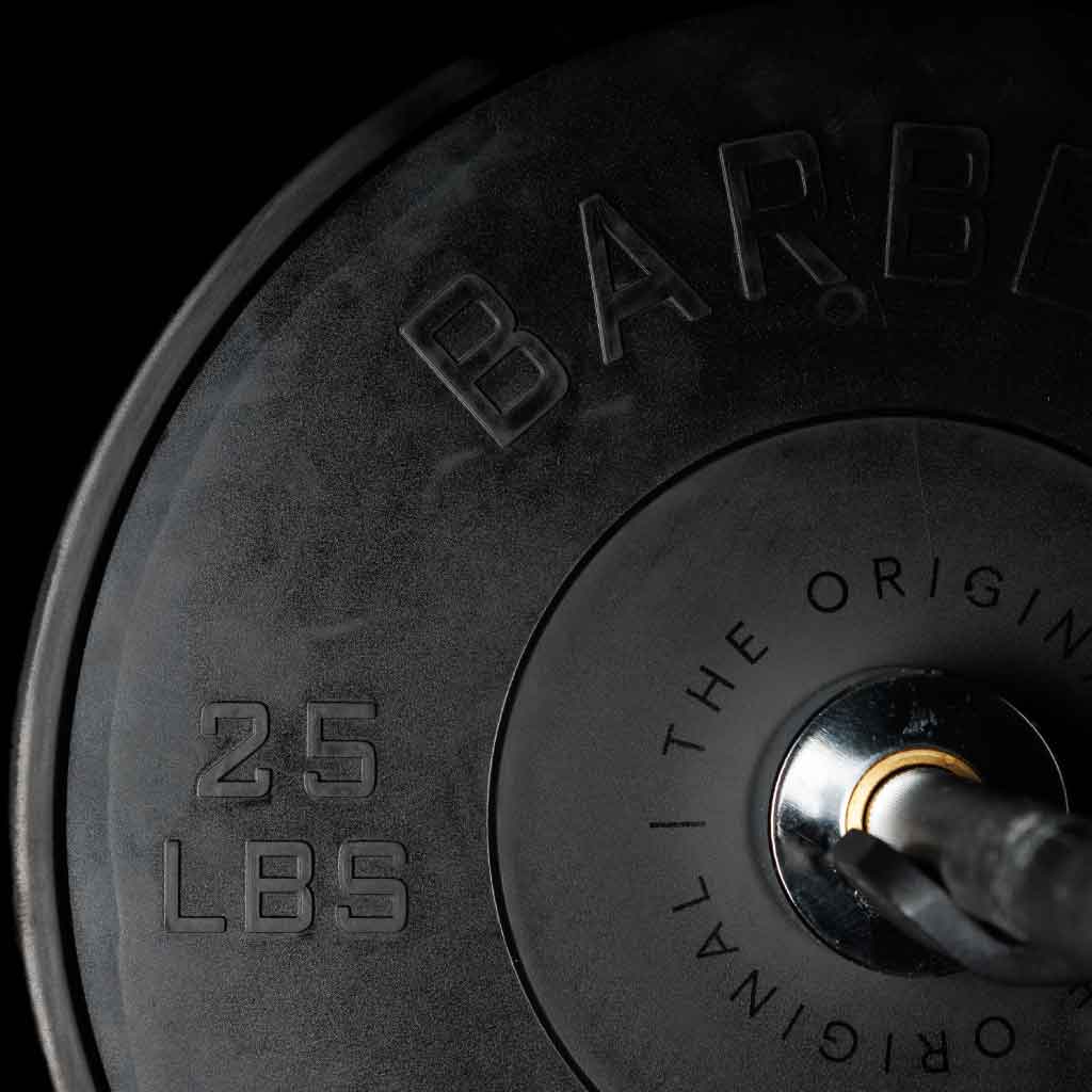 A set of black Olympic bumper plates with raised lettering and the Barbell Standard logo on the center.