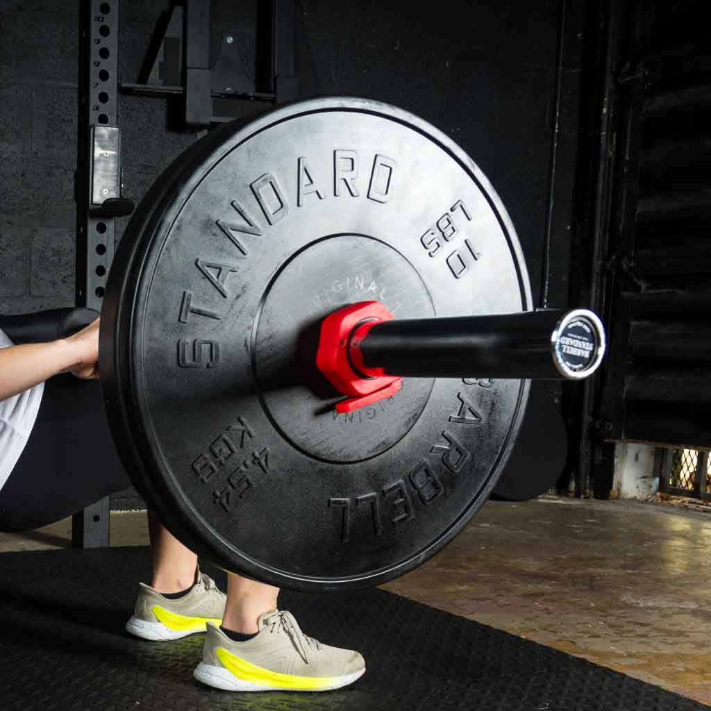 Athlete performing hip thrust with Barbell Standard barbell and 45 lb rubber bumper plates secured with red collar clamps