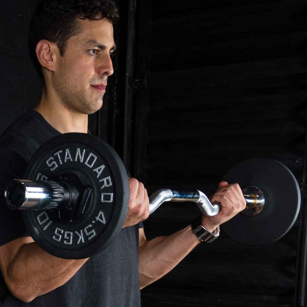 Man performing bicep curls with Barbell Standard EZ curl bar loaded with weight plates in gym
