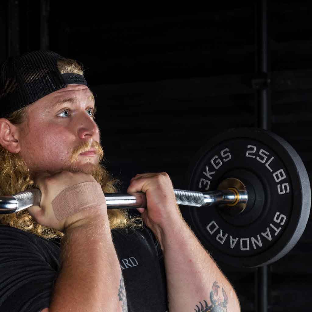 Athlete performing curl with Barbell Standard EZ curl bar and 25 lb plates for strength training
