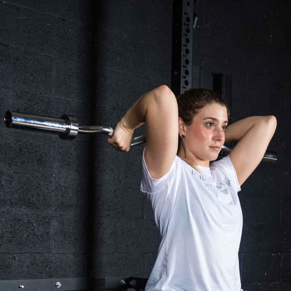 Athlete performing tricep extension with Barbell Standard EZ curl bar in gym setting