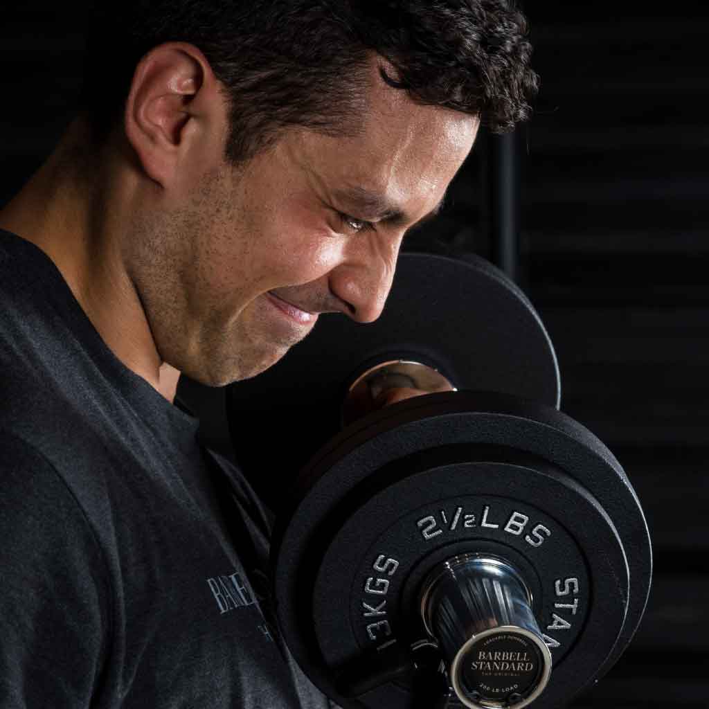 Man performing intense dumbbell curl with Barbell Standard adjustable dumbbell in gym