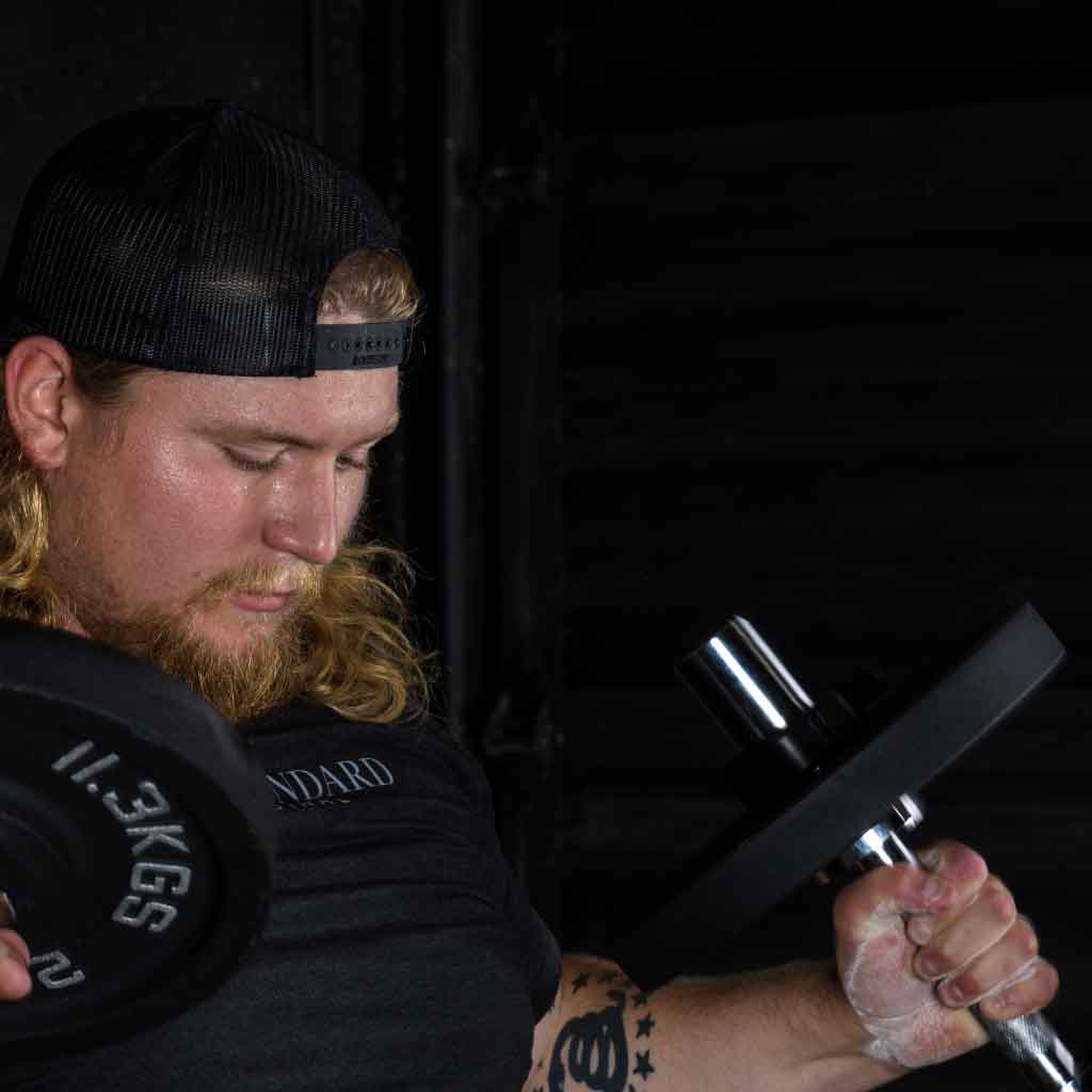 Man performing bicep curl with Barbell Standard adjustable dumbbell during strength training workout