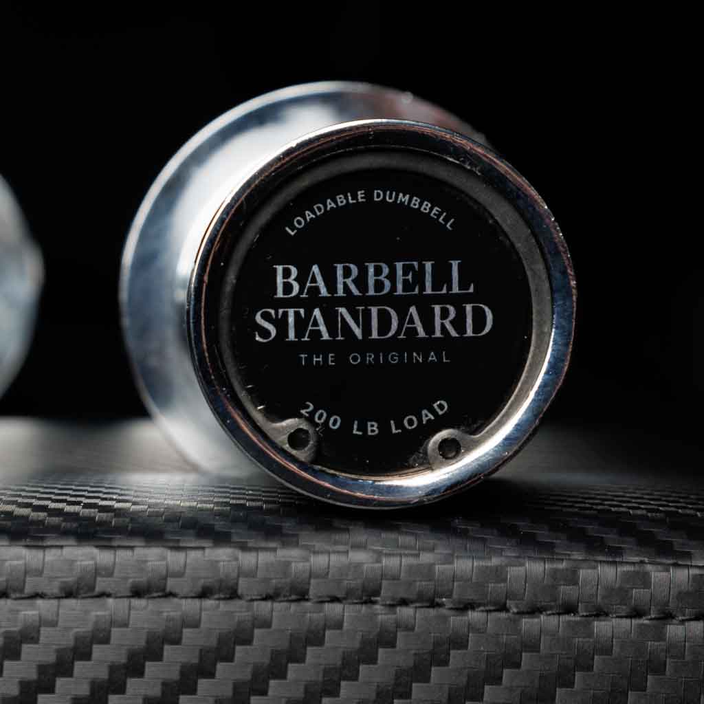 Barbell Standard loadable dumbbell endcap with 200 lb capacity on carbon fiber bench surface