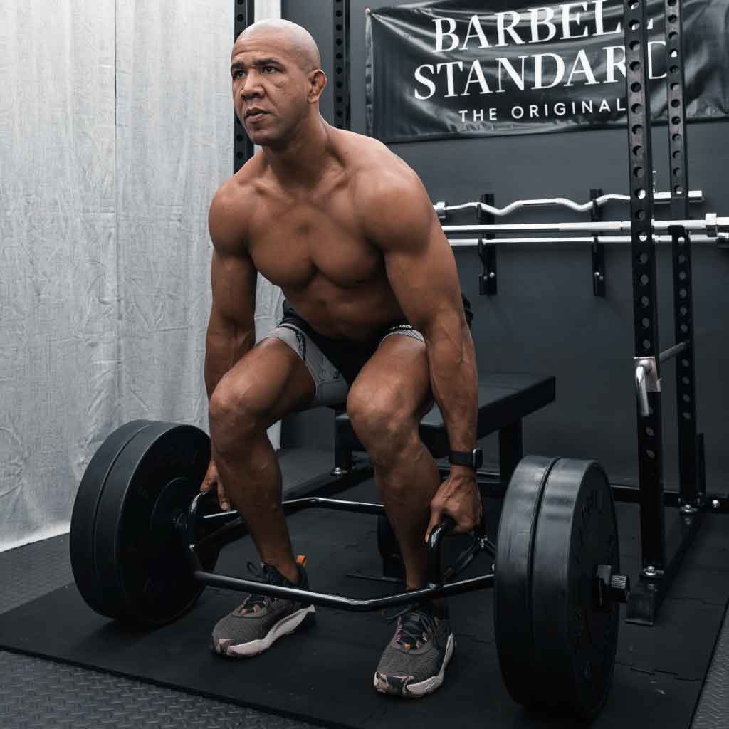 Man performing deadlift with Barbell Standard Trap Bar 2.0 loaded with weight plates in home gym