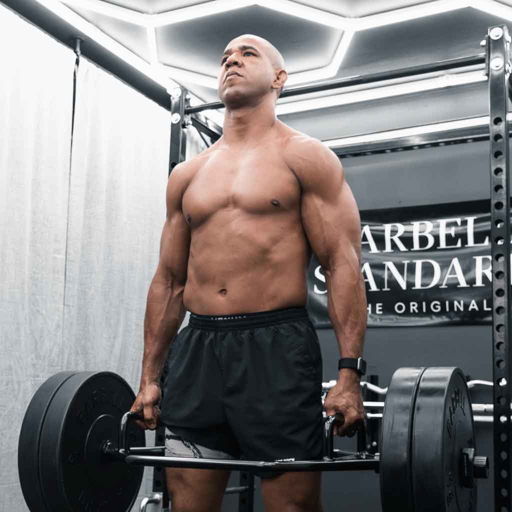 Man performing deadlift with Barbell Standard Trap Bar 2.0 loaded with weight plates in home gym