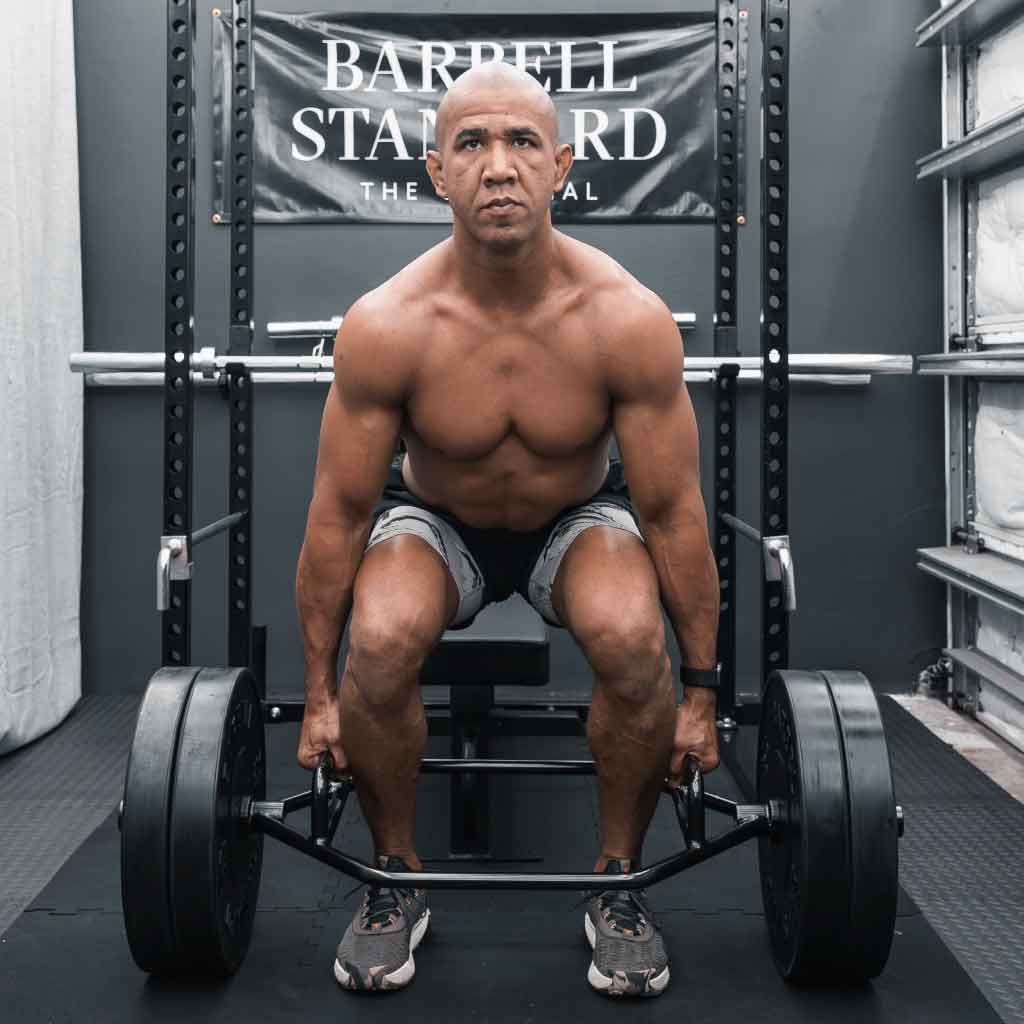 Man preparing to deadlift with Barbell Standard Trap Bar 2.0 loaded with weight plates in a home gym
