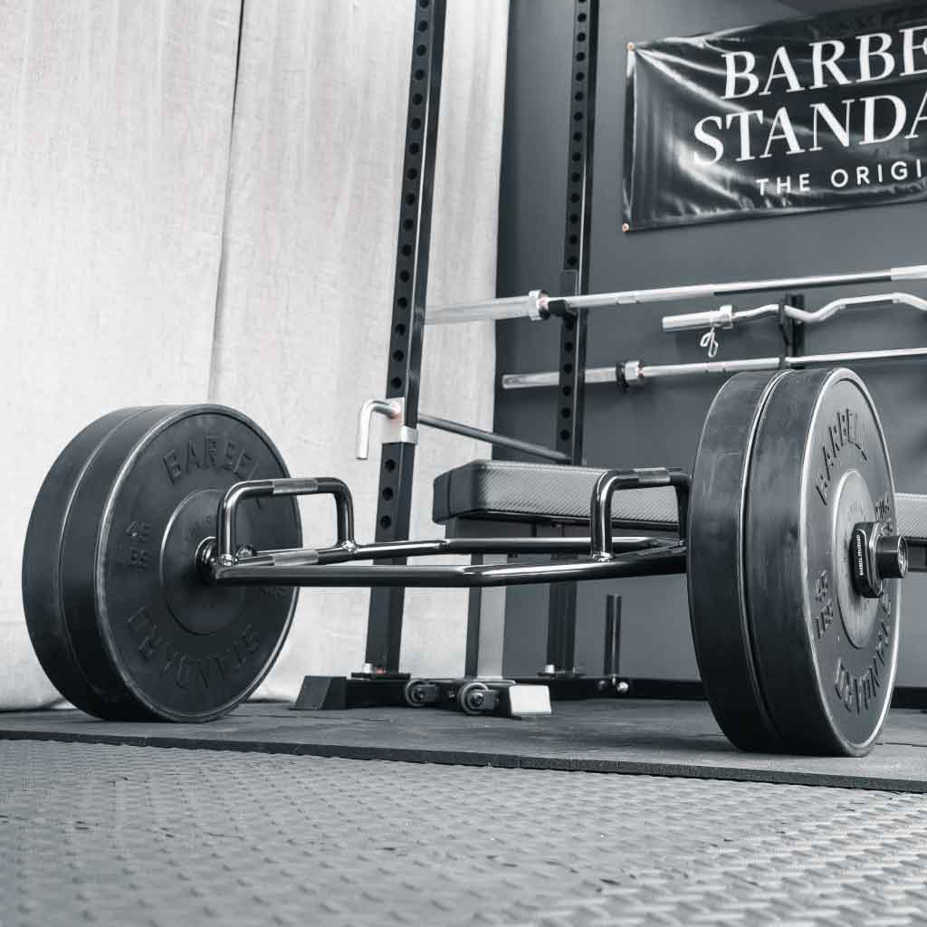 Barbell Standard Trap Bar 2.0 loaded with weight plates in a home gym power rack setup