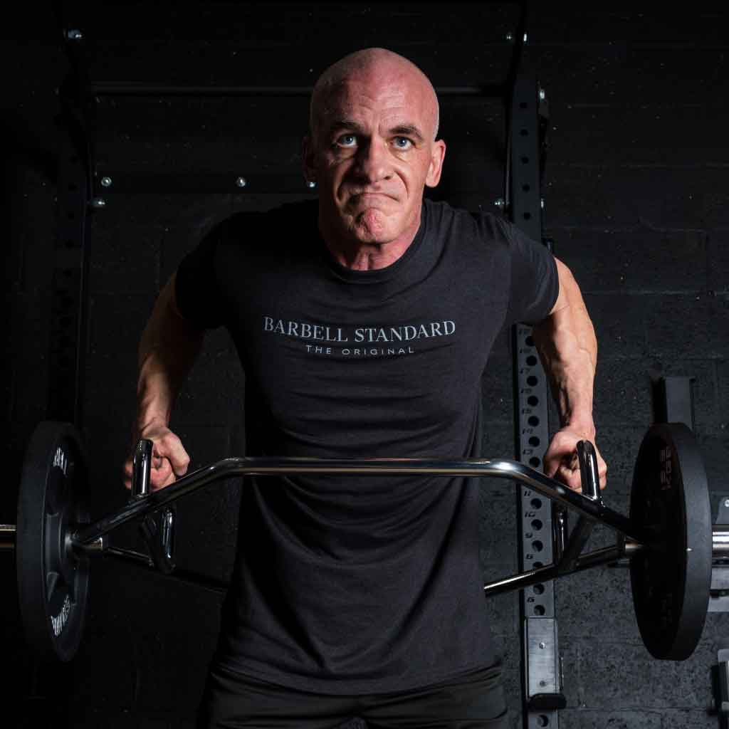 Man performing barbell row with Barbell Standard hex trap bar in gym setting