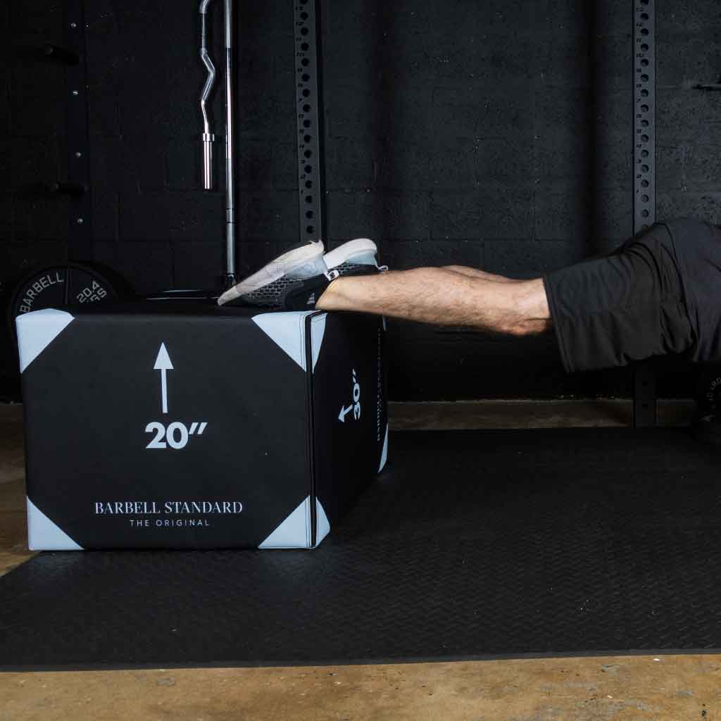 Man performing decline push-up with feet elevated on Barbell Standard 20-inch foam plyo jump box in gym