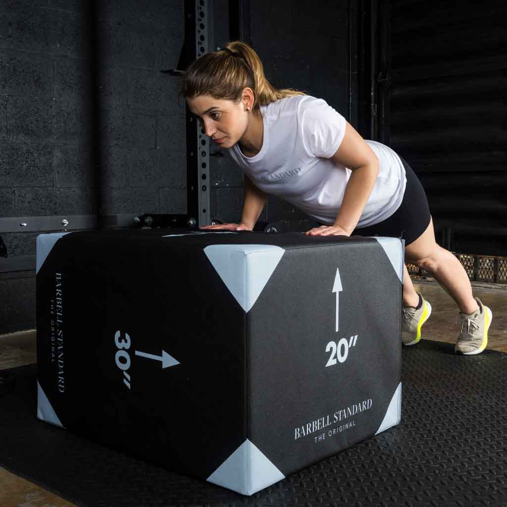 Woman performing incline push-ups using Barbell Standard 3-in-1 foam plyo jump box set at 20-inch height in gym