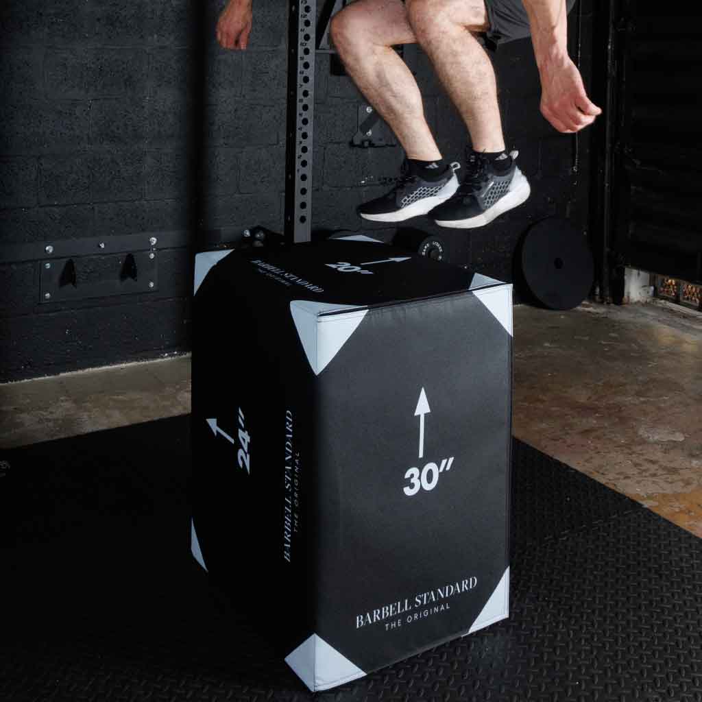 Athlete jumping onto Barbell Standard 30-inch foam plyo box during explosive plyometric training in gym