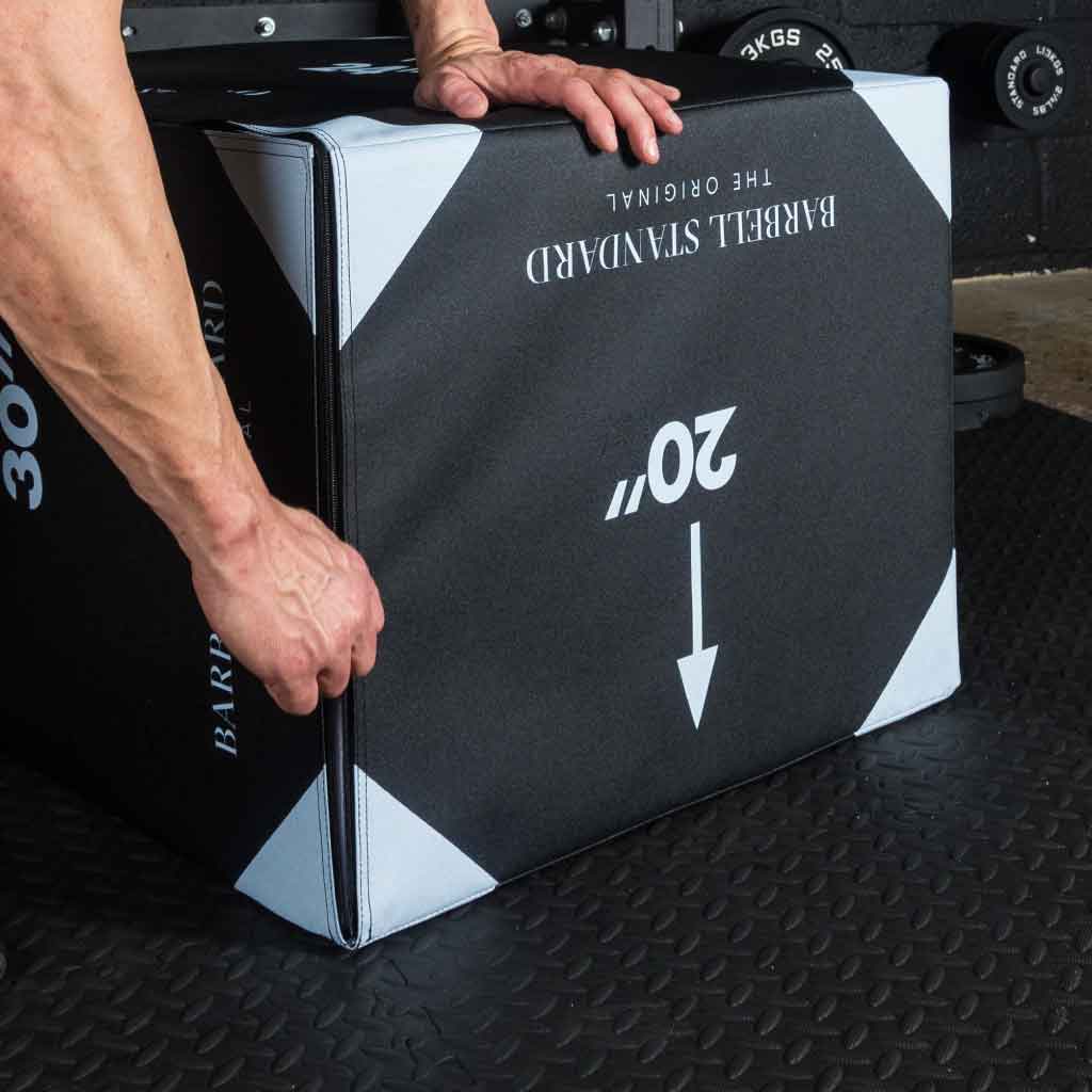 Close-up of man’s hands adjusting Barbell Standard 3-in-1 foam plyo jump box with visible zipper and 20-inch side