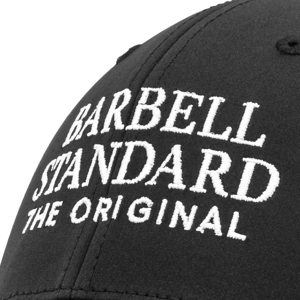 Close-up of Barbell Standard performance hat showing detailed white embroidered logo on the black fabric.