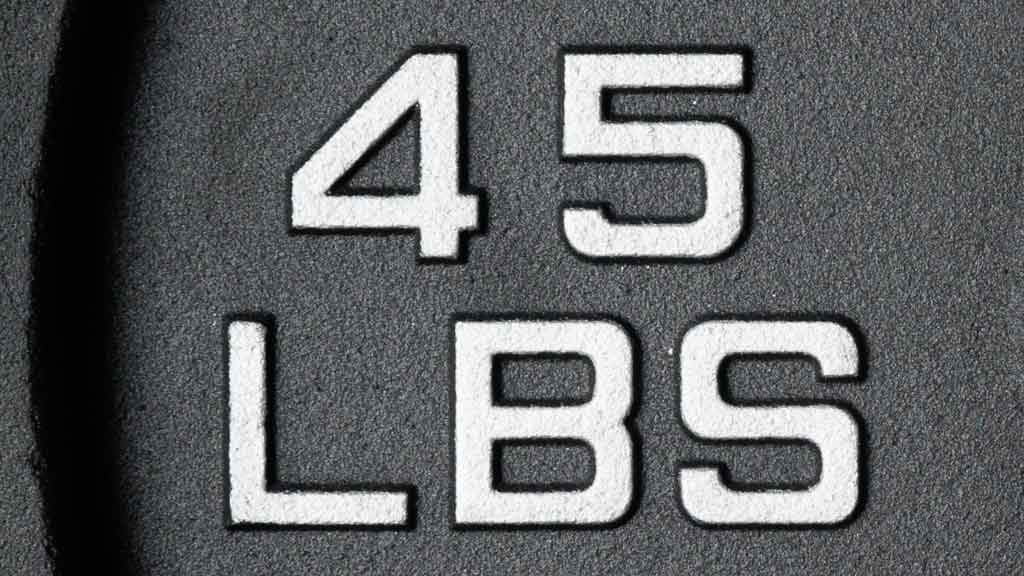 Close-up of 45 LB raised silver lettering on cast iron weight plate