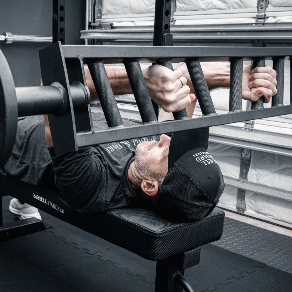 Athlete performing tricep extensions on a bench with the Barbell Standard Swiss Multigrip Bar