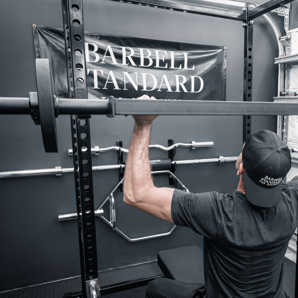 Athlete performing overhead press with the Barbell Standard Swiss Multigrip Bar in a power rack