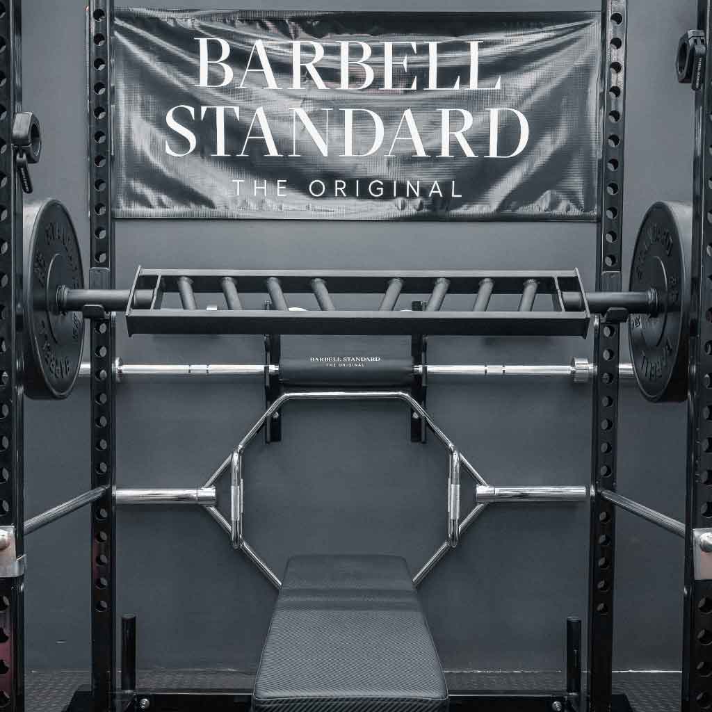 Barbell Standard Swiss Multigrip Bar racked on a power rack with weight plates in a home gym